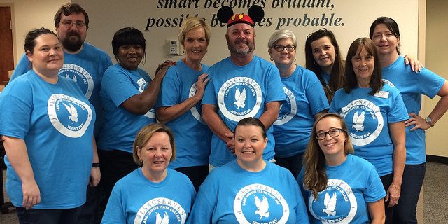 group of employees in blue service day tshirts
