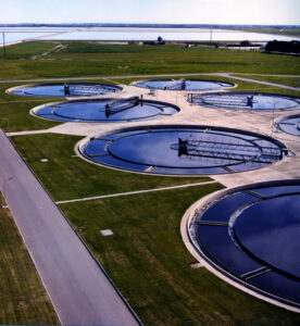 Aerial view of a water treatment plant with circular tanks and roads