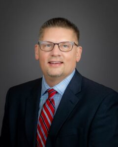 Photo of a man in a suit with glasses