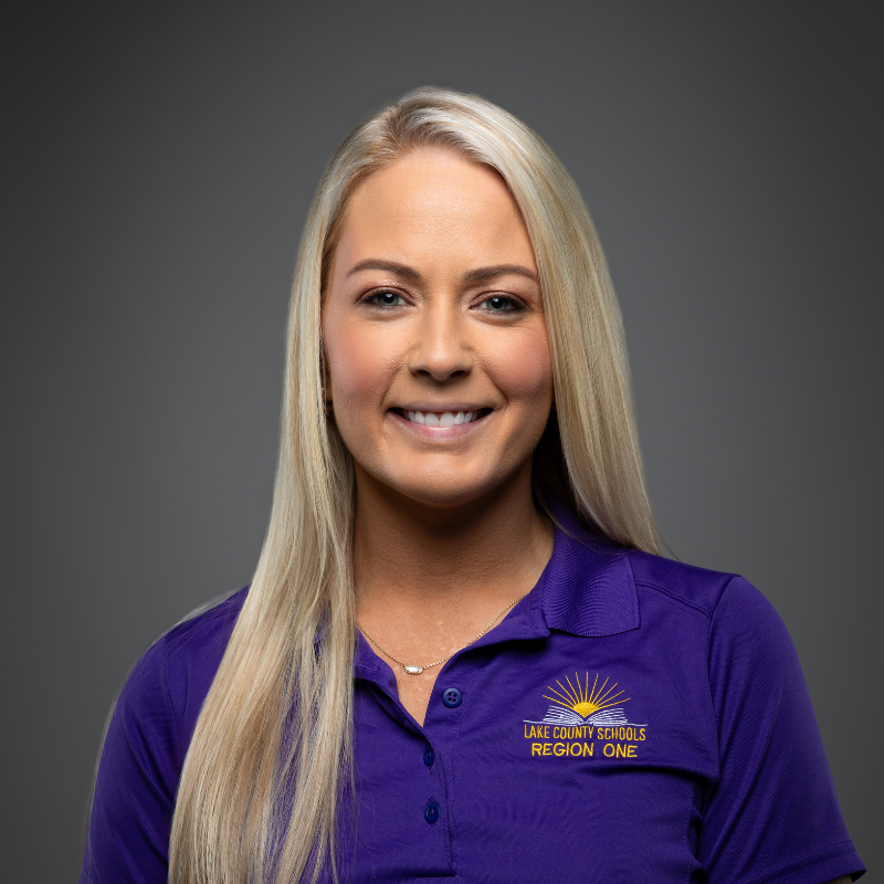 A woman with long straight blonde hair smiles at the camera. 