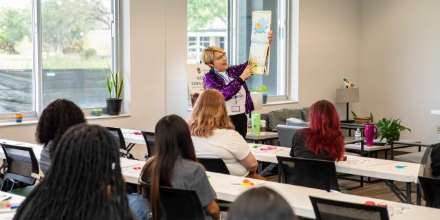 Teacher reads a book to the class