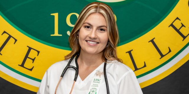 Nurse in white scrubs smiling