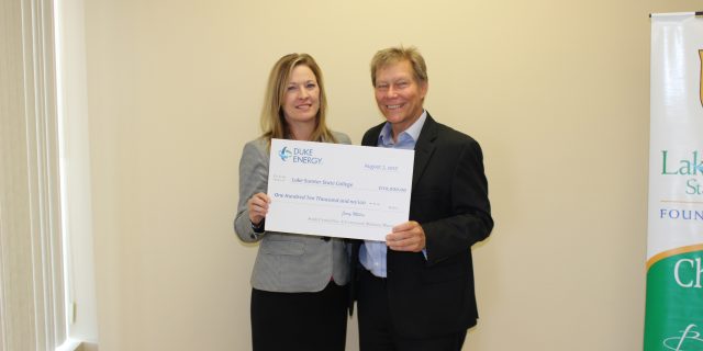Two people holding donation check