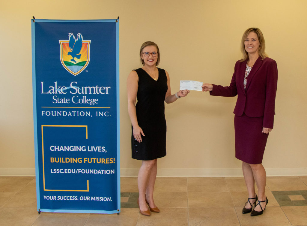 Alise Morris hands a check to Dr. Laura Byrd