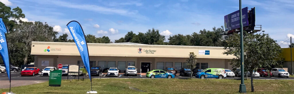 Photo of Building M with AdventHealth branded cars parked in front