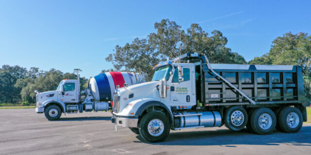 Dump parked parked next to a cement truck on display