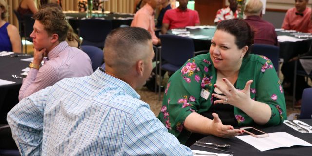 Photo of two people people engaging in conversation at a table