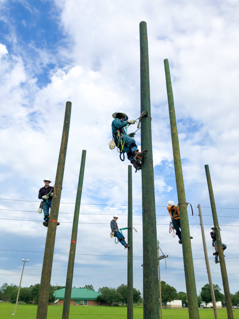 Lineworker students climbing on their utility poles