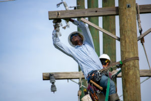 Lineworker student works atop the utility poles