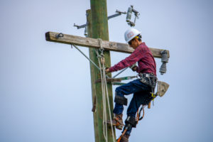 Lineworker student works atop the utility poles