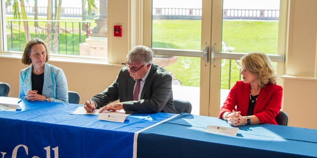 Dr. Patricia Okker (left), New College President, and Dr. Heather Bigard (right), LSSC Provost & Executive Vice President look as Dr. Stan Sidor, LSSC President, signs the transfer articulation agreement between the two schools.