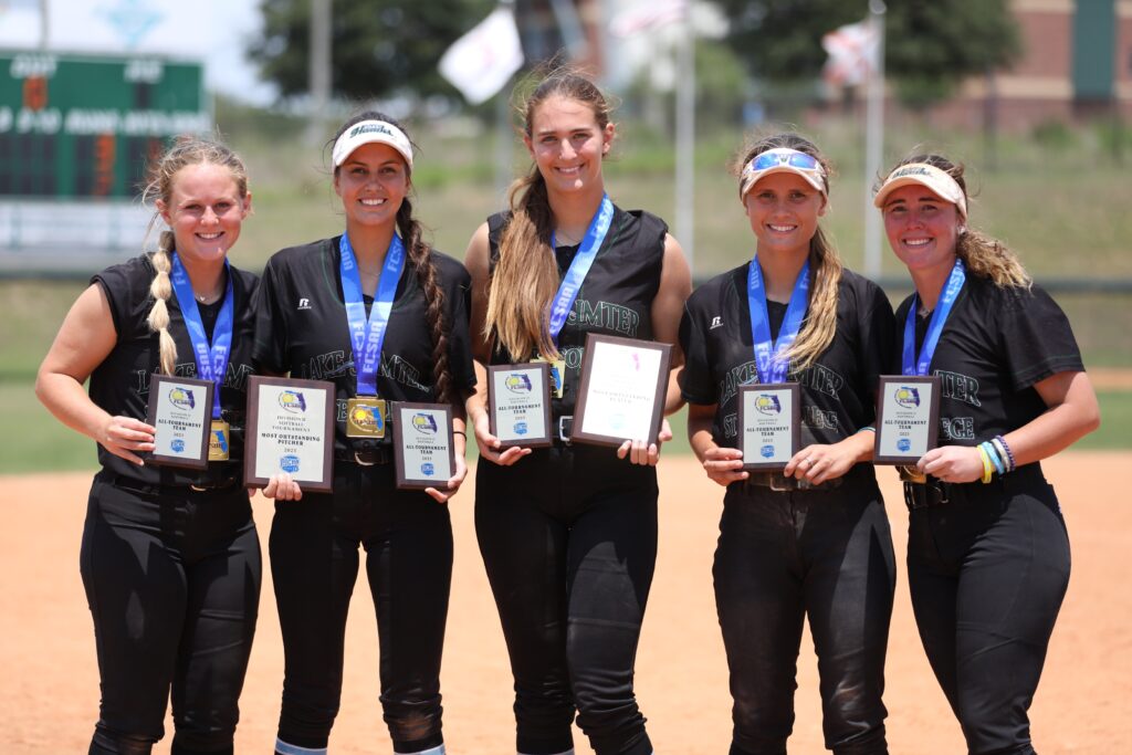 Softball players pose with their awards