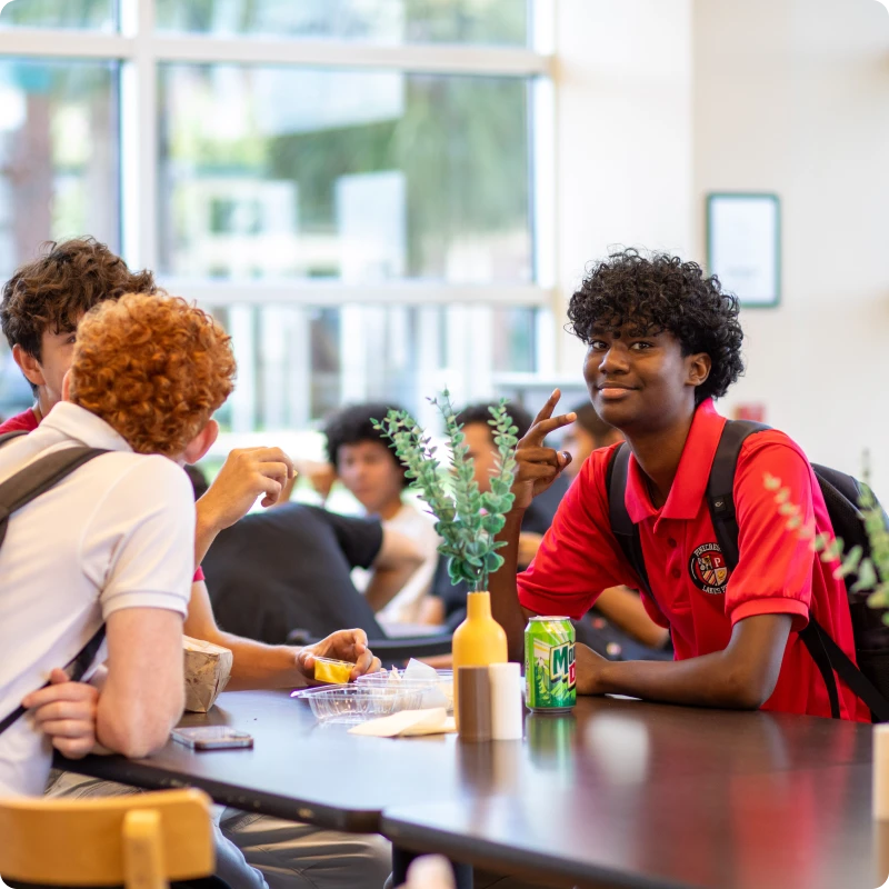 Teenagers sitting at a table, laughing and talking.