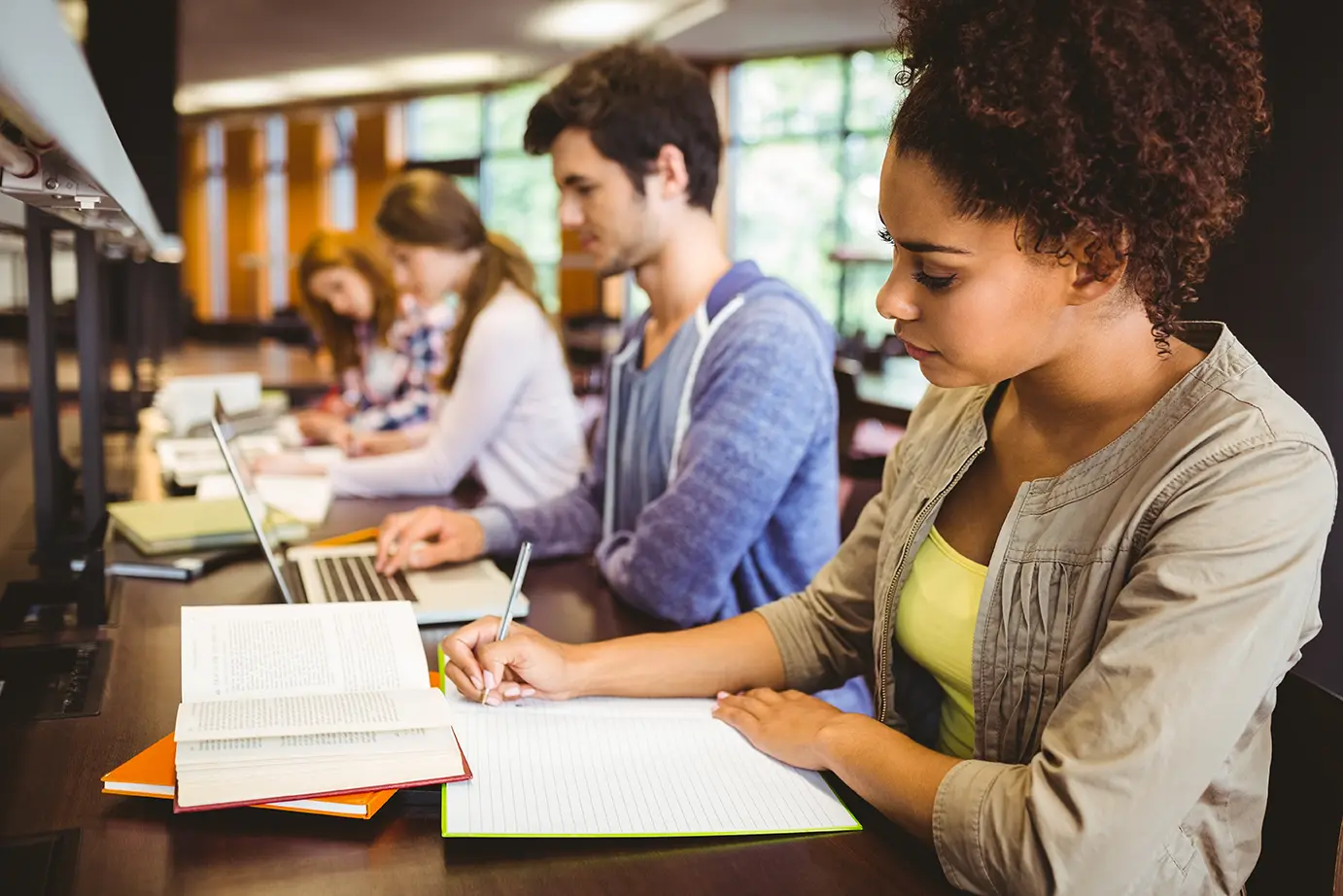 focused students sitting in a line writing