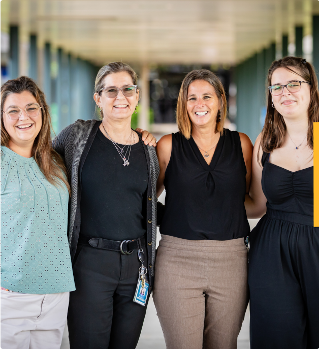 Events and Maretign team memebrrs standing side by side outdoors, smiling at the camera under a covered walkway.