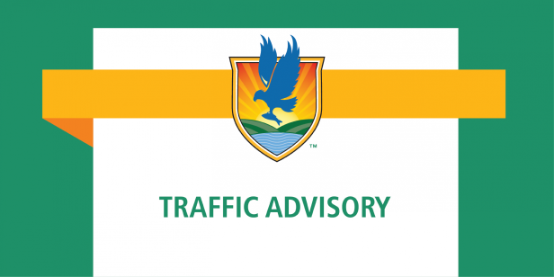Traffic advisory sign with shield logo, bird, sunrise, and river.