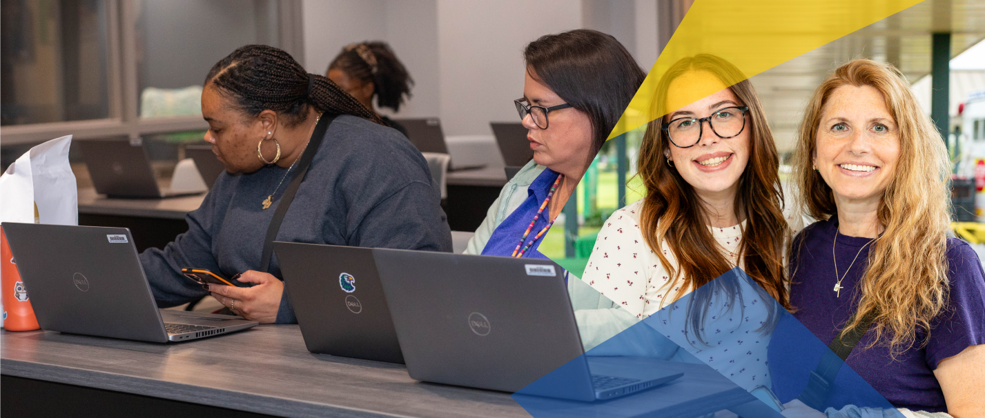 People working with laptops in an office space, with two women standing and smiling in the foreground.