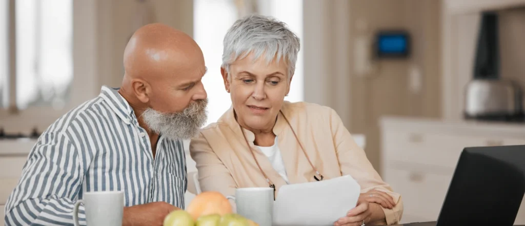 Elderly couple looking at a laptop together.