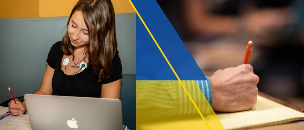 Woman working on a laptop, with a hand holding a pencil and notebook.